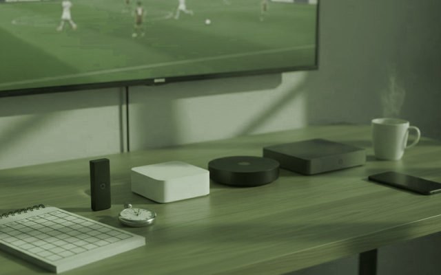 Cinq appareils de streaming, une grille de notation et un chronomètre devant un téléviseur diffusant un match de football